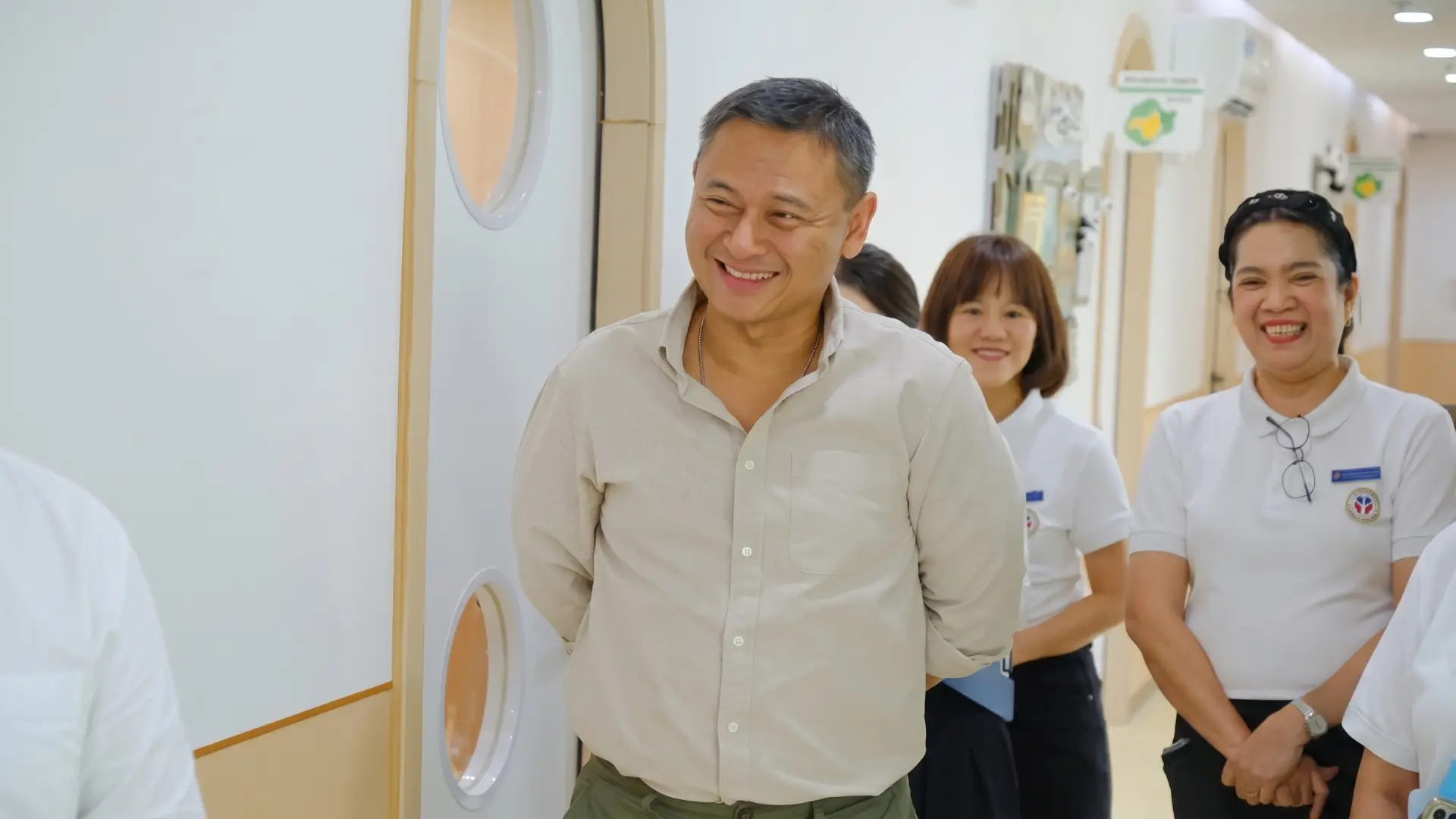 Education Secretary Sonny Angara smiling warmly alongside welcoming faculty members during a special campus tour and school visit at Sproutville International School.